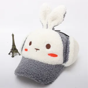 Detalle de gorro de invierno gris con orejas de conejo, bordado de dibujos y forro polar