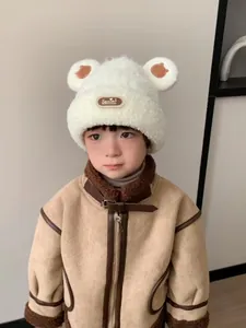 Dettaglio del cappello in peluche bianco per bambini con orecchie da orso e patch