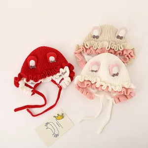 Close-up of knit baby beanies featuring cute 3D ears and delicate bow details