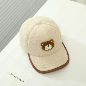 Dettaglio del cappello invernale in pile sherpa con ricamo di orsetto e bordo marrone