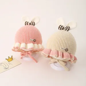 Bonnet tricoté pour bébé avec oreilles de lapin et nœud en rose et beige crème