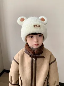 Dettaglio di un cappello di peluche bianco con orecchie da orso e cappotto di pelliccia