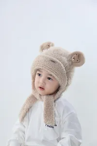 Close-up of children's plush bear hat with earflaps and cute embroidered ears