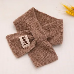 Détail d'une écharpe en polaire marron avec tissu sherpa texturé et étiquette décorative