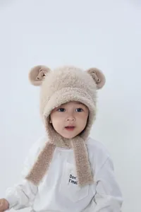 Close-up of khaki plush bear ear hat for kids with delicate teddy bear embroidery detail