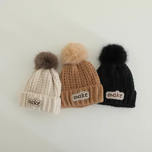 Winter knit beanies for kids with fluffy pom-poms and MAKE letter patch in three colors