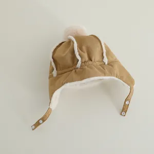 Detail of baby winter trapper hat showing soft faux shearling lining and earflap snaps
