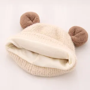 Détail du bonnet en tricot beige pour bébé avec oreilles d'ours et doublure