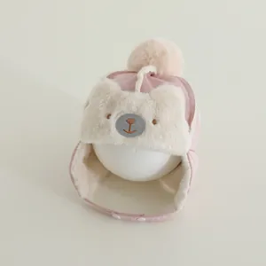 Detail of pink faux suede baby winter hat with plush bear embroidery and pom-pom