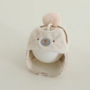 Detail of plush baby trapper hat featuring bear embroidery and soft faux fur lining