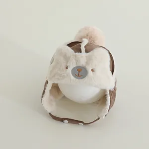 Detailed close-up of brown baby aviator hat with bear embroidery and plush faux fur lining