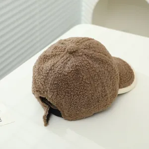 Detail of dark brown faux shearling baseball cap with contrast piping and adjustable strap