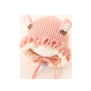 Pink and beige baby knit winter hat with cute rabbit ears and decorative bows
