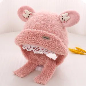 Detail of pink plush kids hat featuring bunny ears, soft faux fur and chin straps