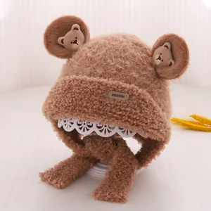 Detailed texture of brown plush baby bear hat with integrated scarf and ear flaps