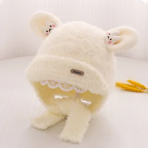 Detailed texture of beige plush bear ear hat featuring cute rabbit patch and ear flaps