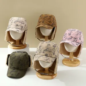 Detailansicht verschiedener Camouflage-Fliegermützen mit warmem Kunstfellfutter