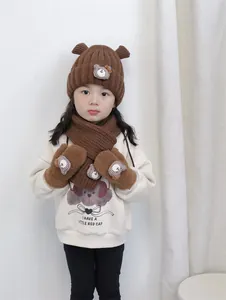 Détail de l'ensemble hiver enfant avec bonnet ours marron, écharpe et gants en peluche