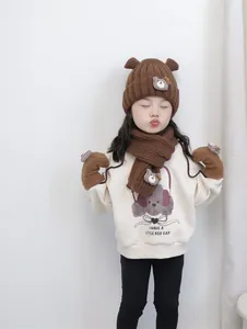 Détail du tricot de l'ensemble bonnet, écharpe et gants d'hiver marron pour enfant
