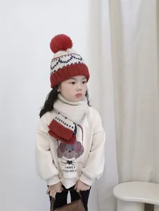 Detail of kids winter set showing pom-pom knit hat, matching scarf and puppy motif sweatshirt