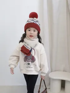 Detail of kids knit hat with pom-poms and matching striped scarf in winter warm set