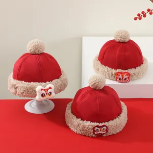 Detalle de gorros de invierno para bebé con bordado de león tradicional y borde de felpa suave