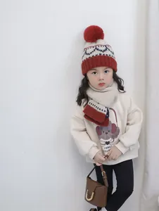 Close-up of kids winter knit hat and scarf set with pom-pom and colorful wave pattern