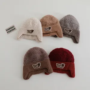 Details von fünf Winterstrickmützen mit Ohrenklappen in verschiedenen Farben und Fleece