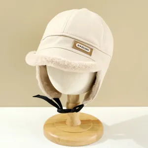 Detail of beige winter aviator hat with soft faux fur lining and buckle strap closure