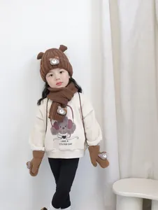 Détail de l'ensemble d'hiver en tricot marron pour enfant avec bonnet, écharpe et moufles