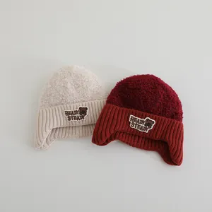 Detail der Strickmütze mit Ohrenschützern, Plüsch-Lammvlies und Bären-Stickerei für Kinder
