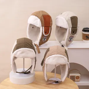Detailed view of color-blocked winter trapper hats with thick warm faux fur lining
