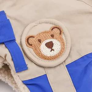 Detail der Bären-Stickerei und warmem Fleece-Futter an der Khaki Wintermütze für Kinder