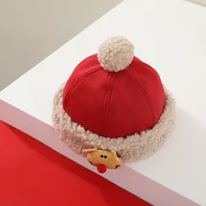 Detalle del gorro de invierno para bebé en lana roja con adorno de reno tridimensional