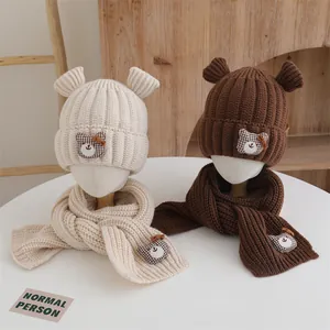 Détail de bonnets et écharpes en tricot pour enfants avec oreilles d'ours et motifs à carreaux