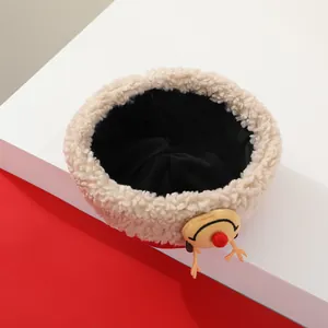 Primer plano de gorro navideño de forro polar beige para niños con detalles de renos