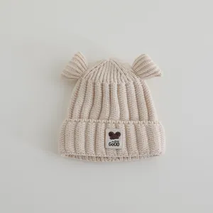 Detail van baby winter gebreide muts met schattige ronde oren en decoratief label
