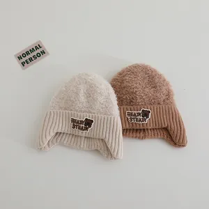 Detailansicht der warmen Wintermütze für Kinder mit Bären-Patch in Beige und Braun