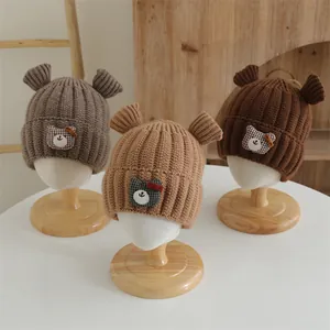 Détail de bonnets d'hiver en tricot avec oreilles d'ours pour bébés en tons marron