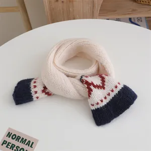 Close-up of knit scarf with diamond patterns and navy contrast ends for kids