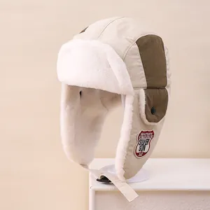 Detail of winter trapper hat featuring warm faux fur lining and embroidered badge