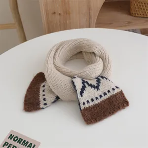 Close-up of thick knit scarf with geometric patterns in cream, navy, and brown colors