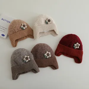 Detail von fünf verschiedenen Winterstrickmützen mit Ohrenklappen und 3D-Blumen