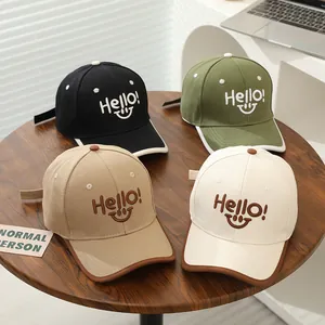 Detail of four colorful kids baseball caps featuring Hello embroidery and smiley faces