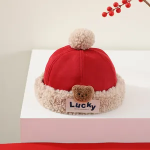 Detalle del gorro de invierno rojo para bebé con bordado de oso y ribete de lana de cordero