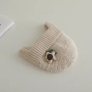 Detail der cremefarbenen Strickmütze mit Blumenakzent und weicher Fleece-Textur für Kinder