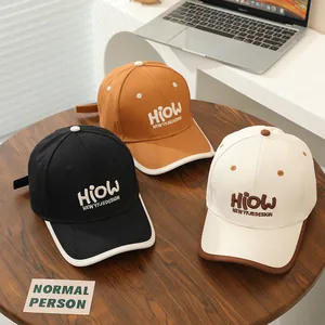 Detailed view of HIOW embroidery on cotton baseball caps in black, orange and beige