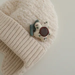 Detailansicht der beigen Kindermütze mit Fleece-Textur und dekorativer Stoffblume