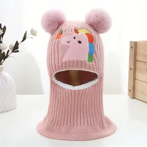 Pink knitted baby dinosaur balaclava with fluffy pom-poms and unicorn embroidery