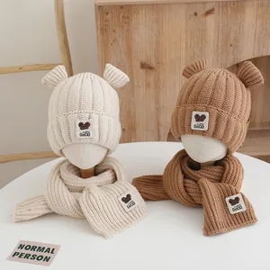 Gros plan détaillé des bonnets à oreilles d'ours et écharpes assorties pour enfants